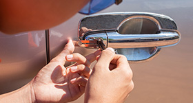 a locksmith lockpicking a locked out car