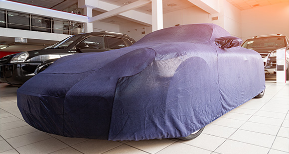 a car covered in a blue tarp for storage